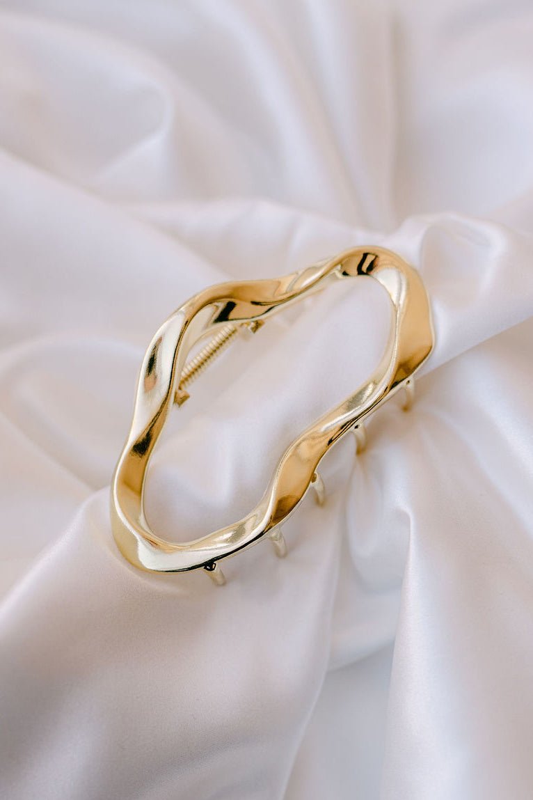 Gold claw clip on white fabric background. Handmade Canadian jewelry, hair accessories, & everyday hair pieces Canada