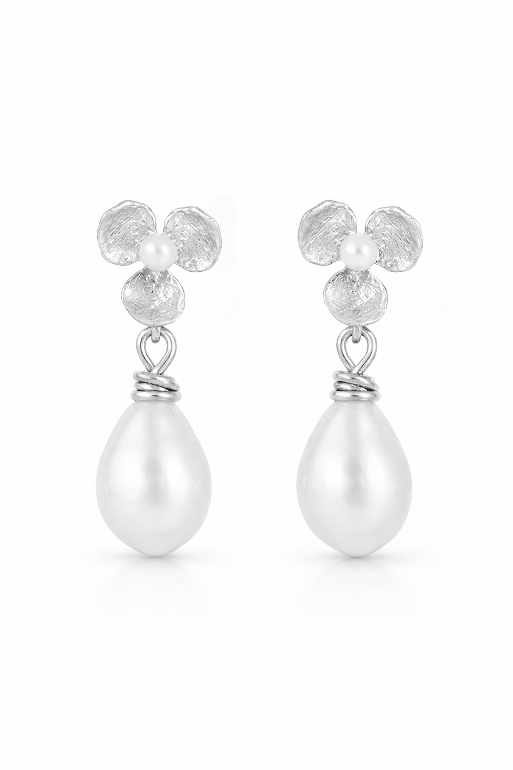Pair of silver pearl earrings with flower accents on a white background. Bridal flower earrings handmade in canada