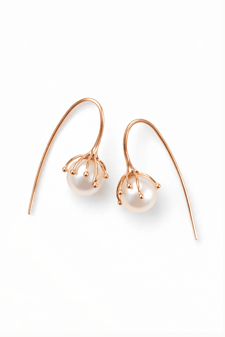 Pair of pearl flower bud wedding earrings with gold hooks on a white background