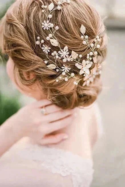 A twisted bridal hairstyle with a gold, crystal, and freshwater pearl floral hairvine.