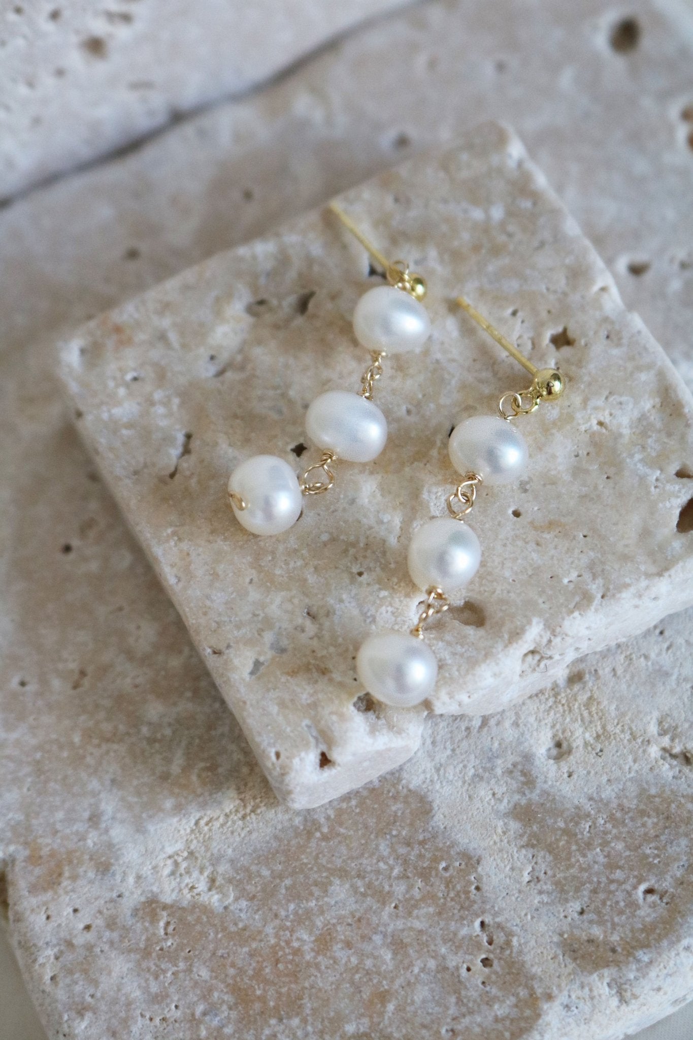 Isla Drop Fresh Water Pearl Studs Lay on Stone.