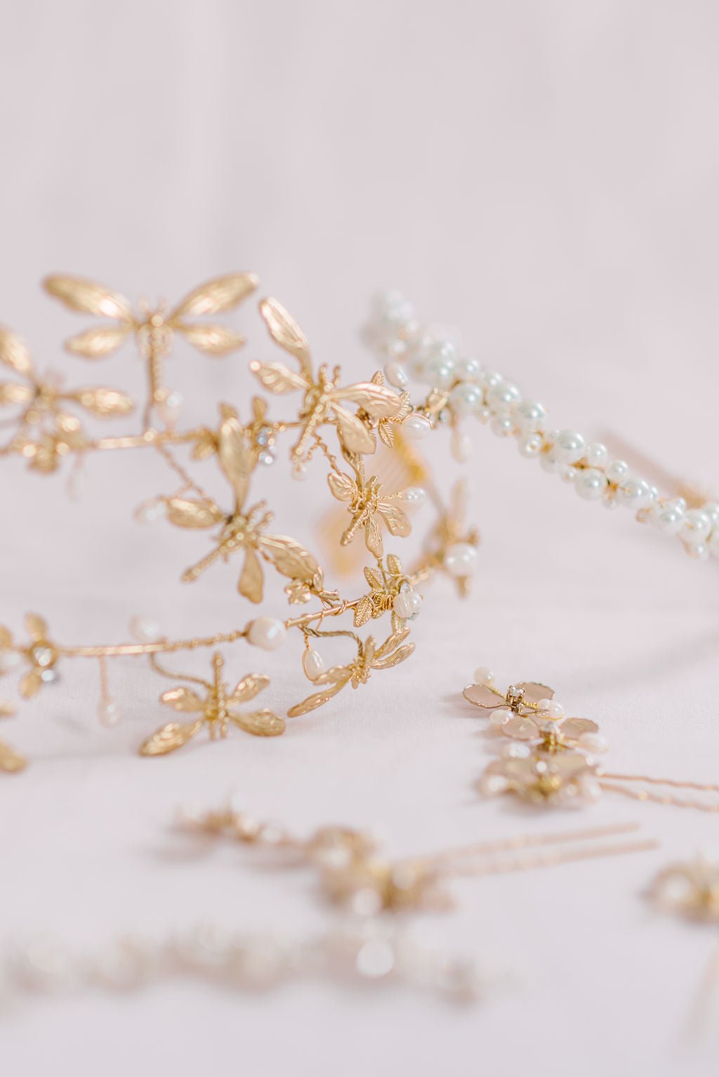 Golden double banded freshwater pearl dragonfly crown among various bridal hair pins. 