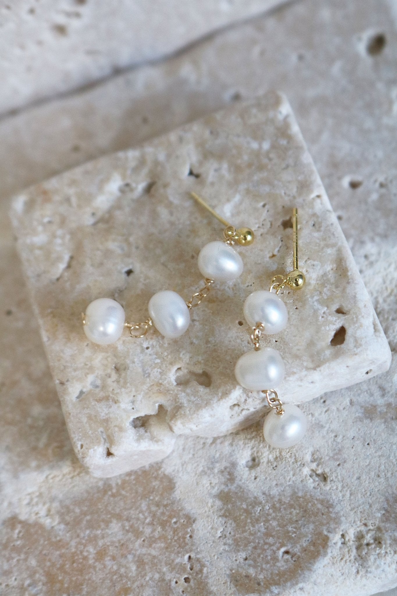 Isla Drop Fresh Water Pearl Studs Lay on Stone.