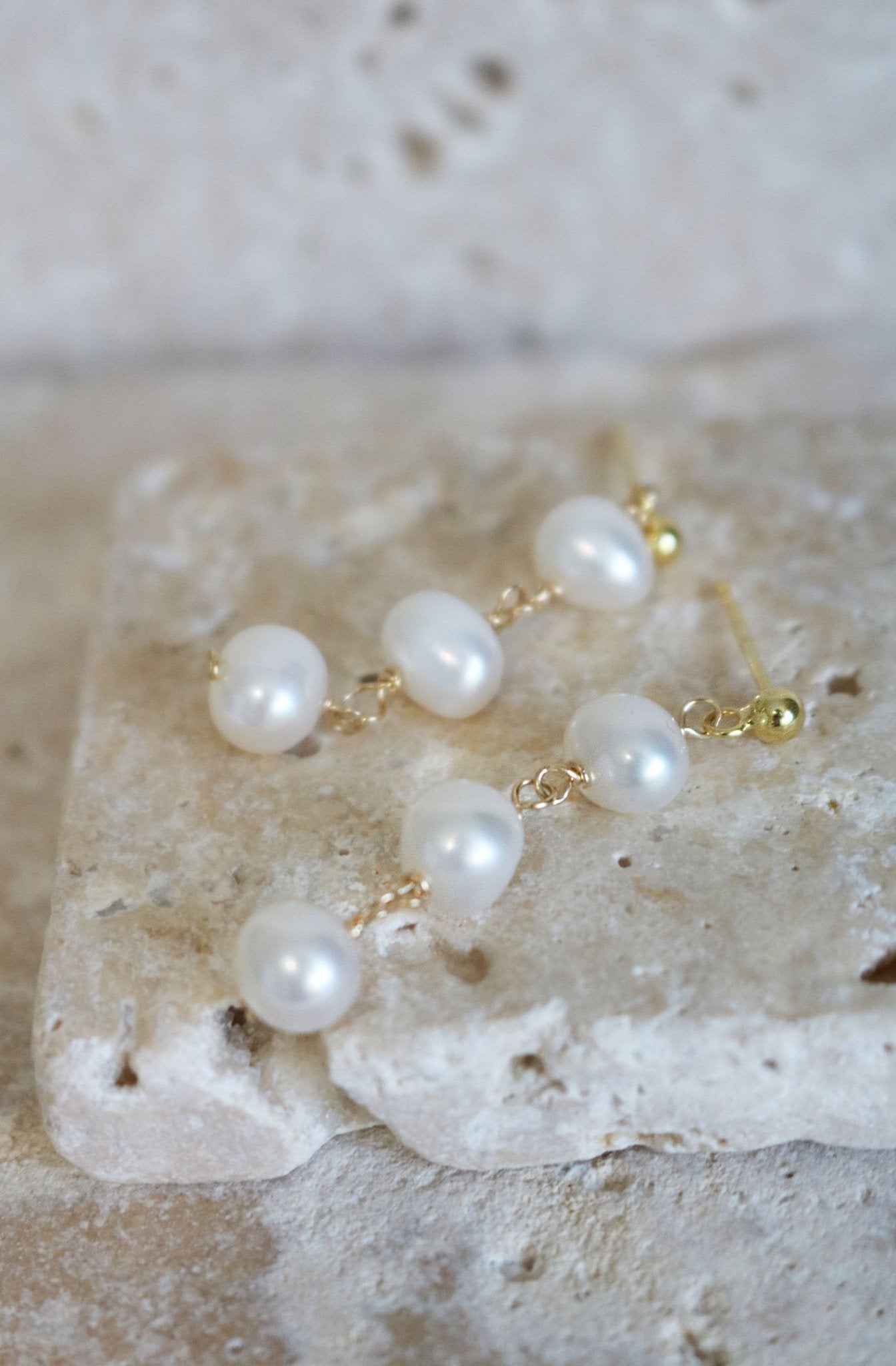 Isla Drop Fresh Water Pearl Studs Lay on Stone.