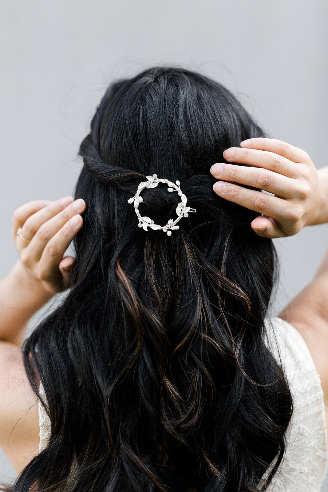 Sterling Silver laurel hoop barrette with crystals and freshwater pearls clipped in dark wavy hair.