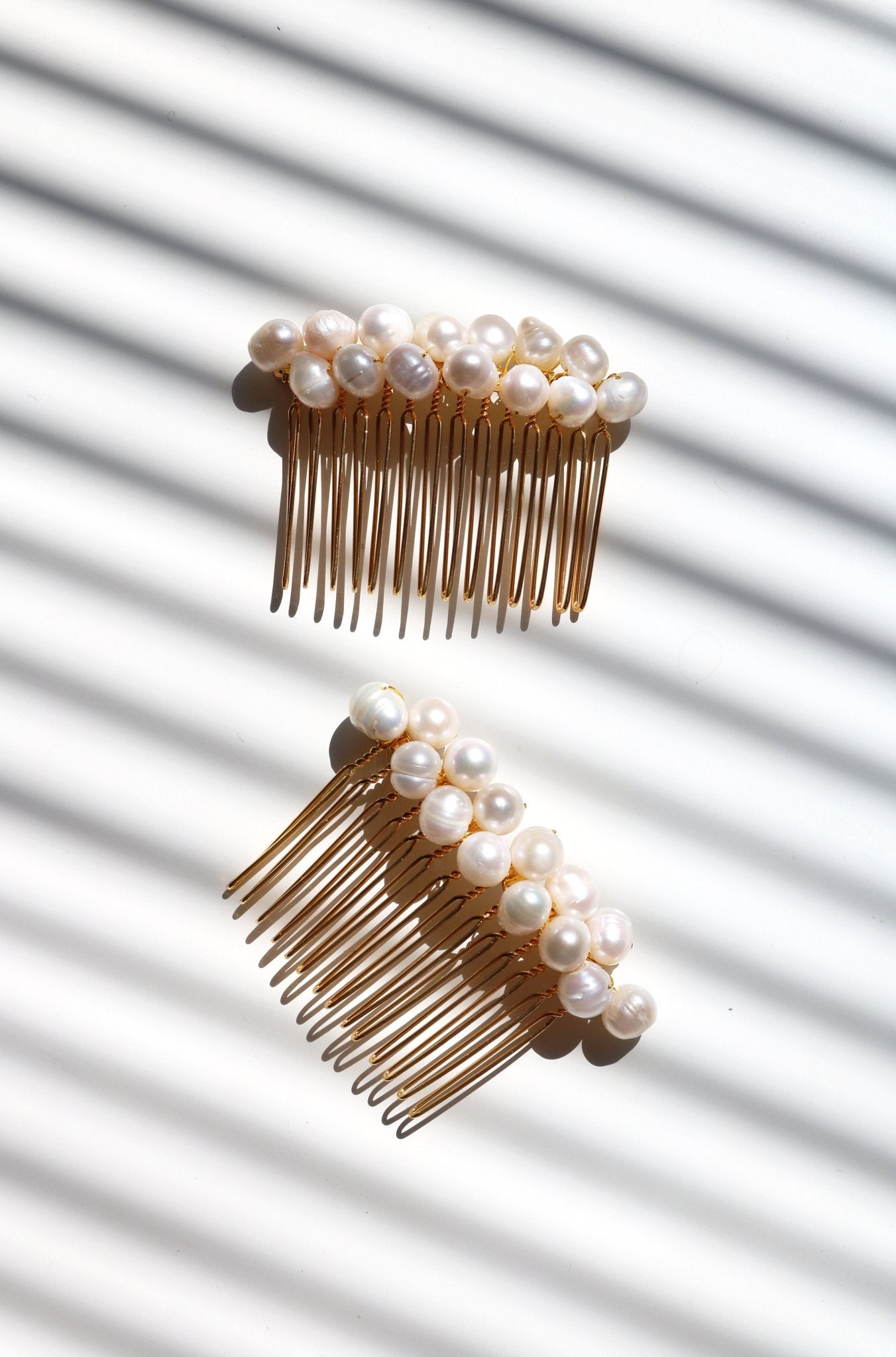 Two Adelle Pearl Combs in gold. 