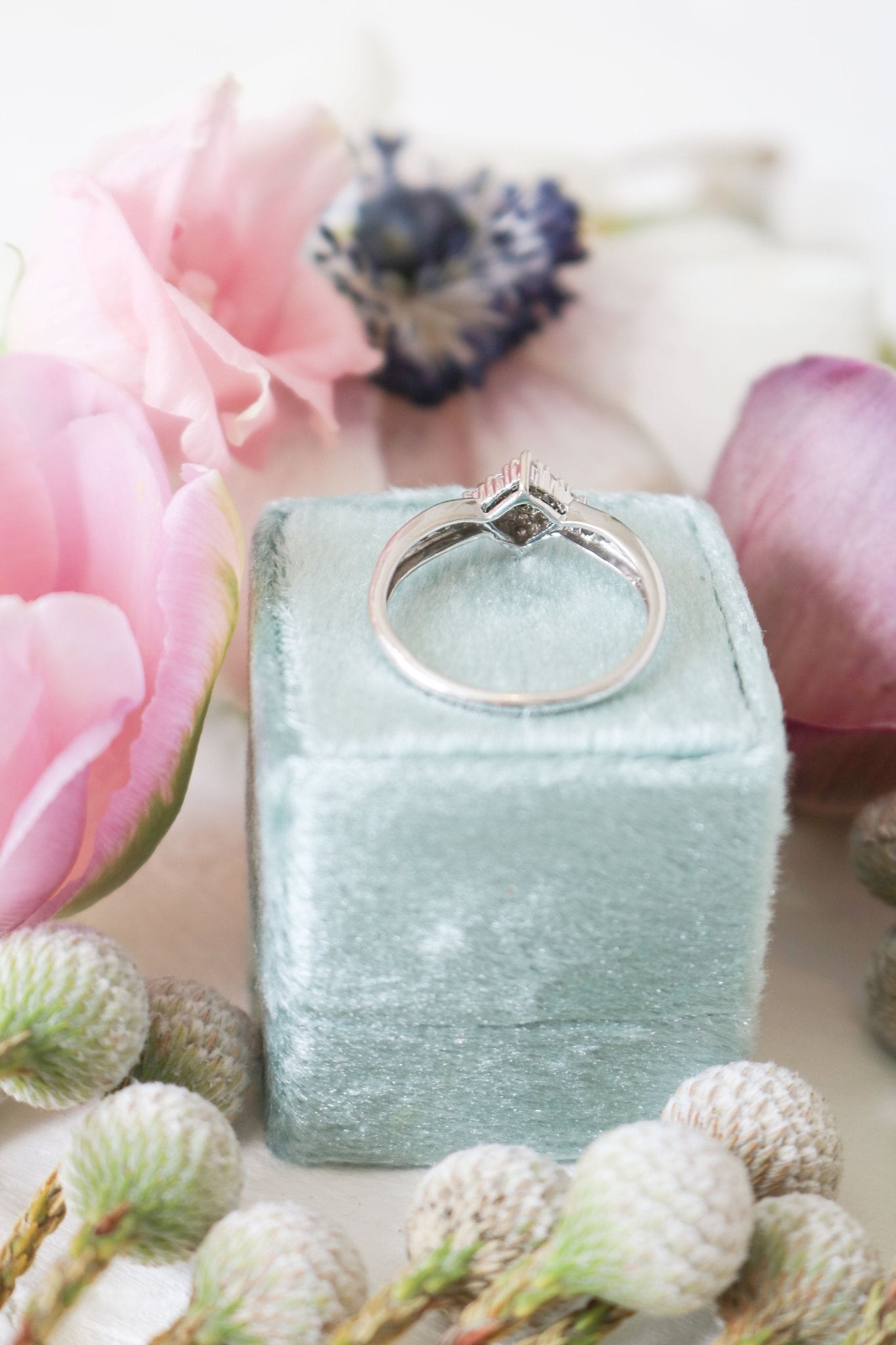 Antique diamond engagement ring in 9ct white gold atop a seafoam green ring box. 