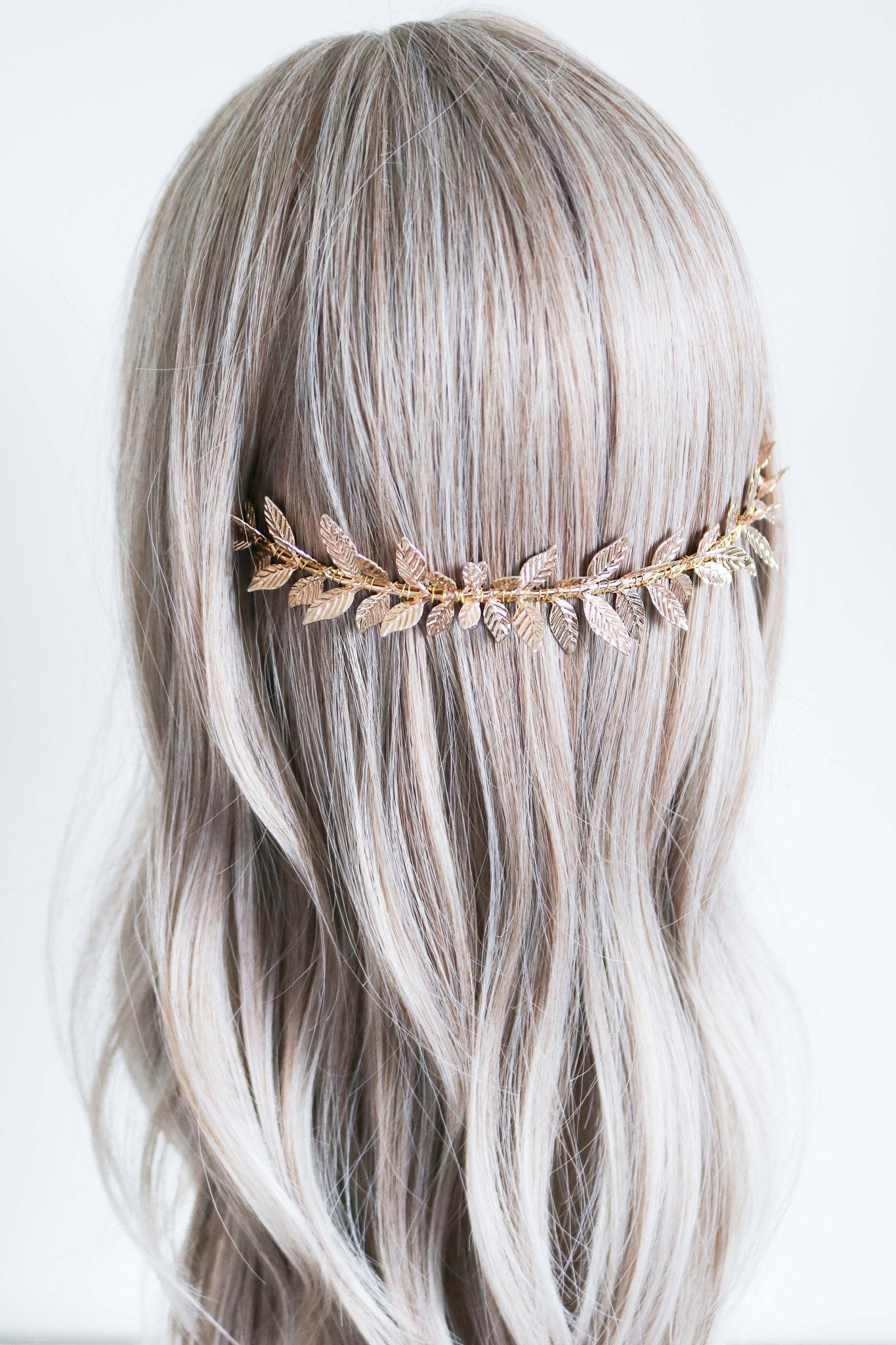 Wedding headband with gold dipped laurel leaves set against wavy locks. 