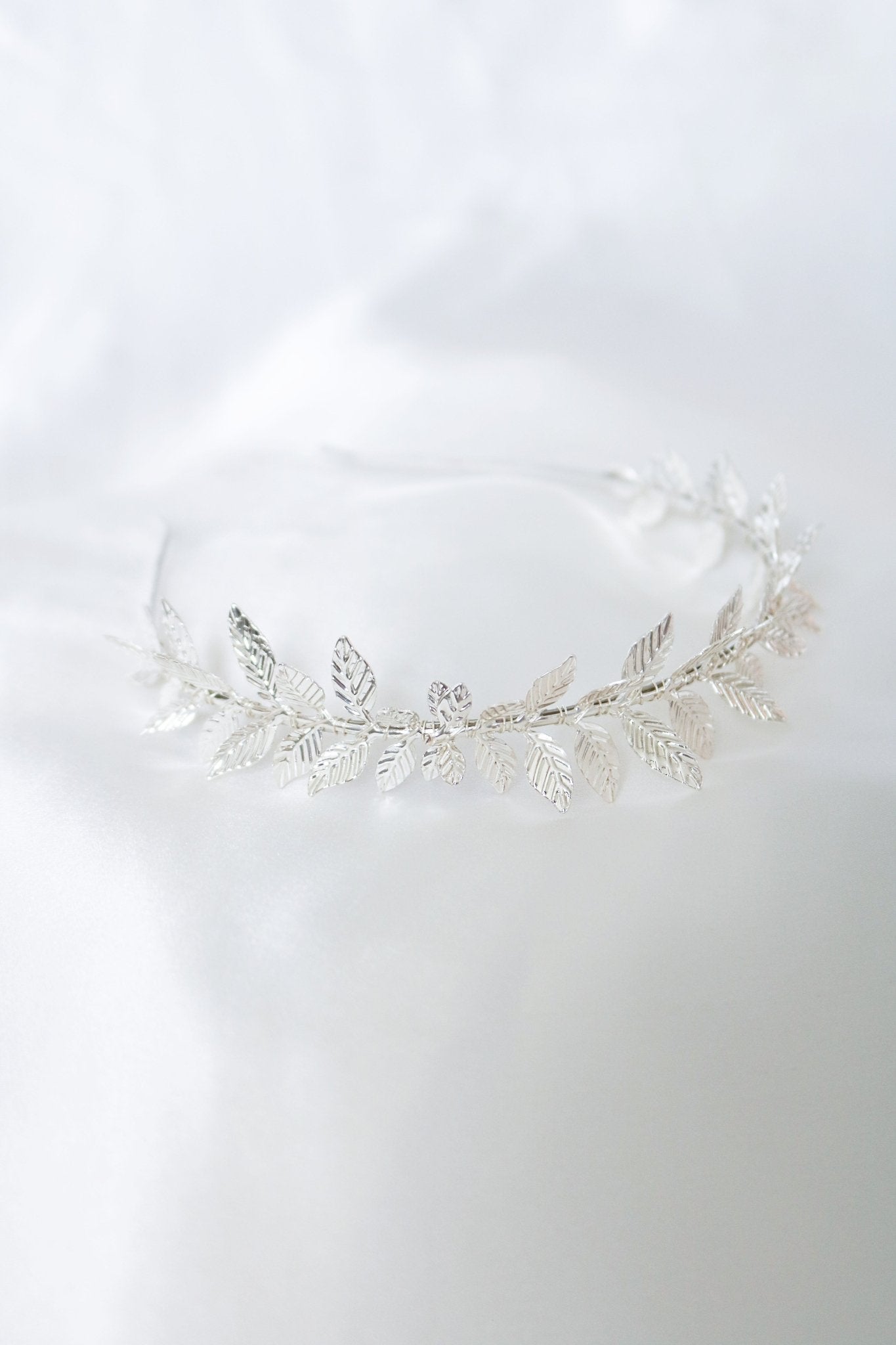 Stunning silver pointed laurel leaves wire-wrapped headband against a white backdrop. 