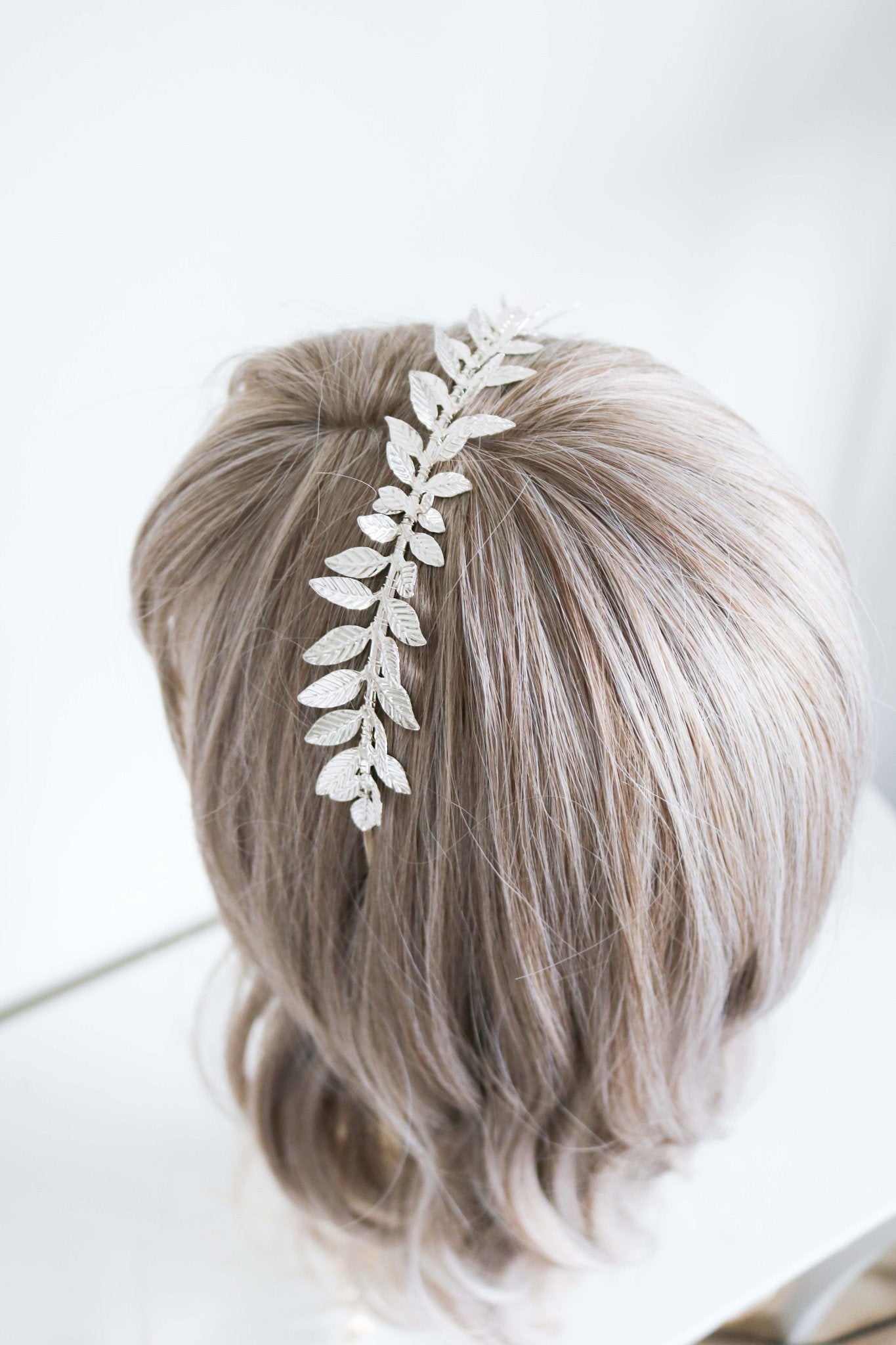 Pointed laurel leaf bridal headband in silver on a head bust. 