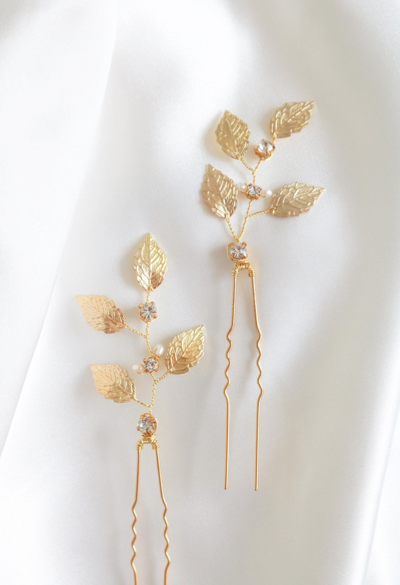 Two wedding hairpins in gold with crystals and pearls.