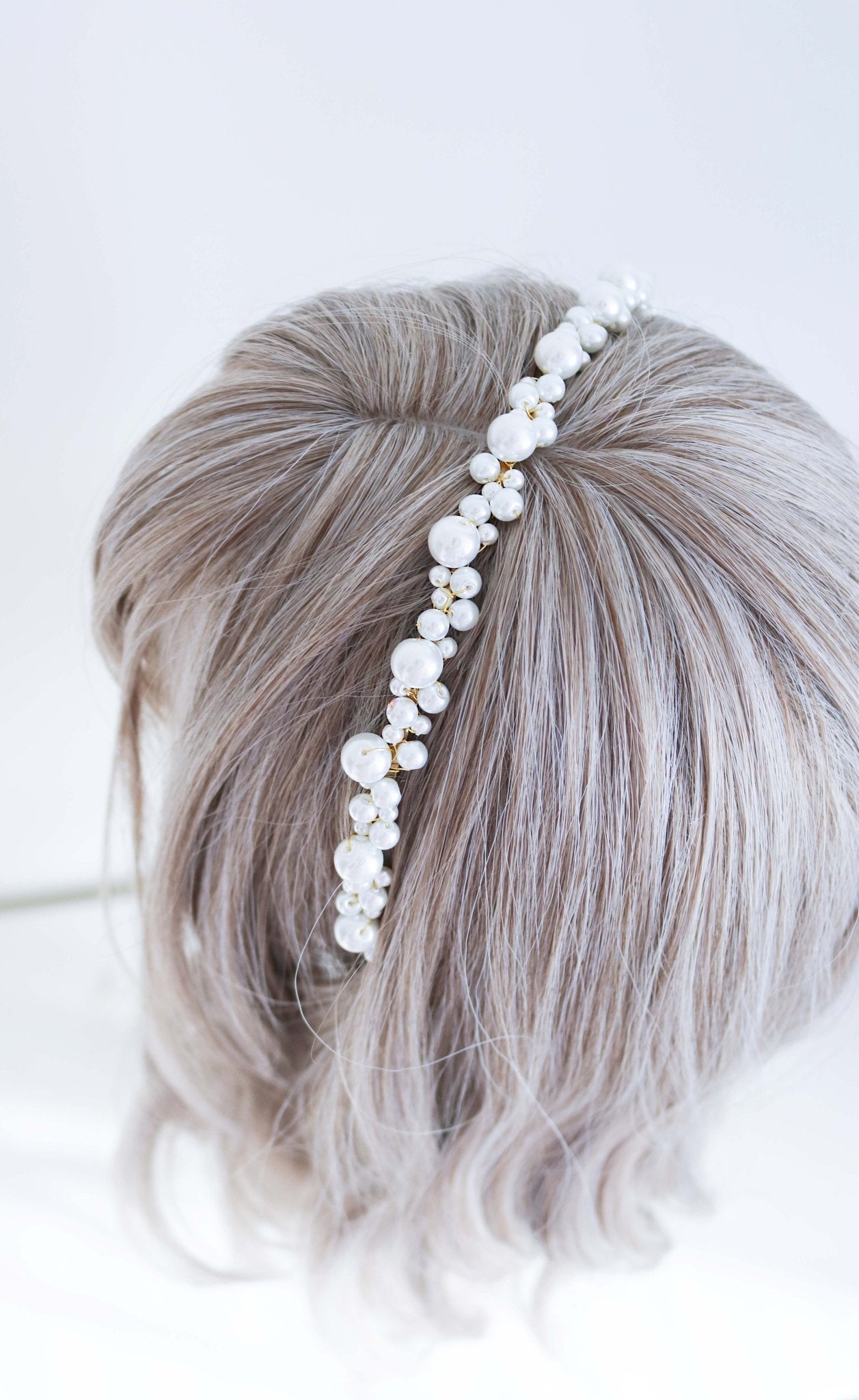 Wire-wrapped wedding pearl headband in gold on ashy blonde wig with white background. Bridal Hair Accessories & pearl bridal accessories by Small Canadian jewelry brand