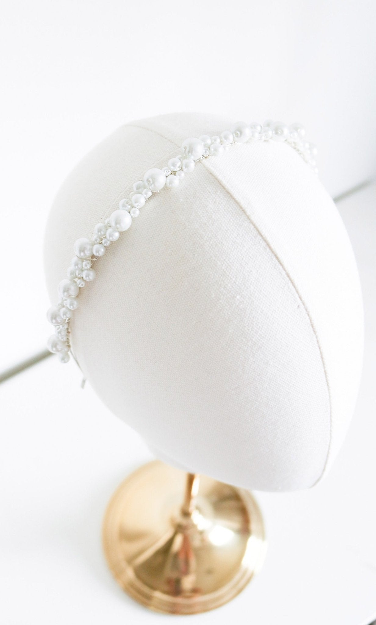 Silver bridal headband with Swarovski pearls on a white head bust on white background. Bridal Hair Accessories & Canadian handmade Accessories by BIPOC bridal designer