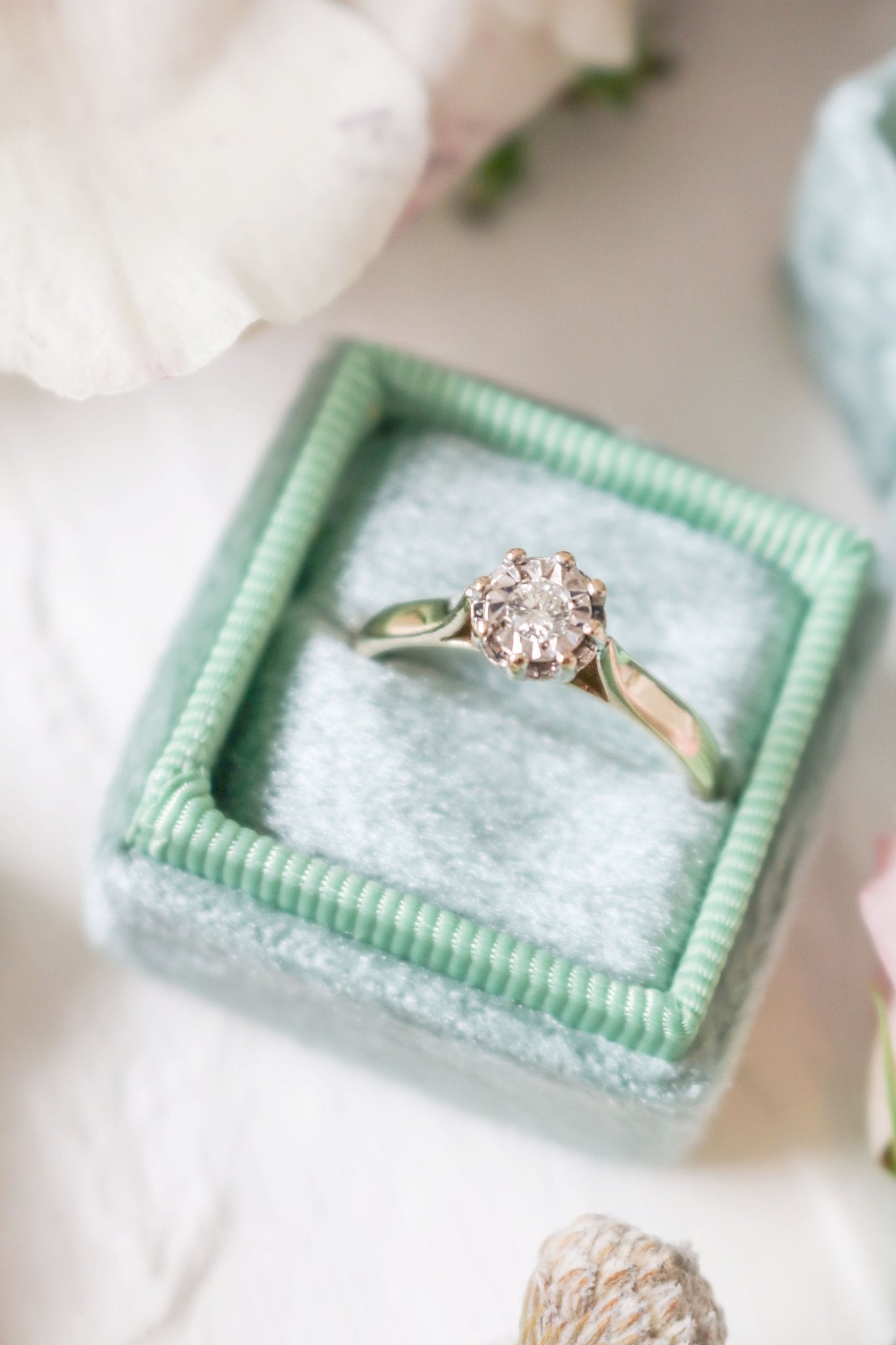 Amelie Vintage Diamond Engagement Ring in 9ct Yellow and White Gold sits in a fluffy seafoam green ring box. 