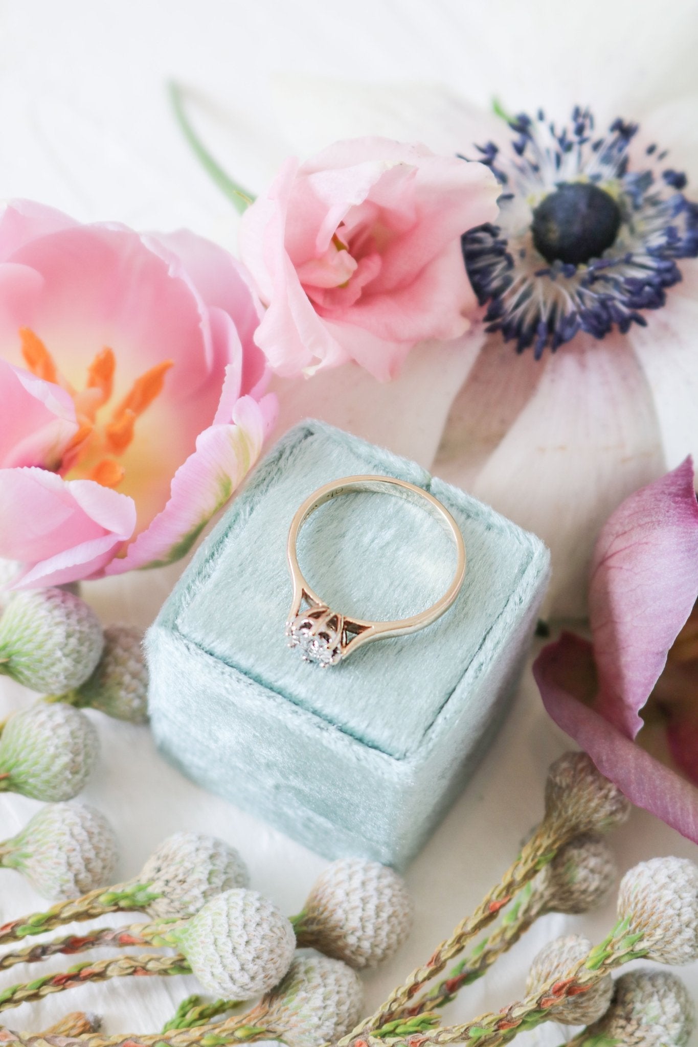 Vintage Engagement Ring in 9ct Yellow and White Gold with Diamond on a ring box among flowers.