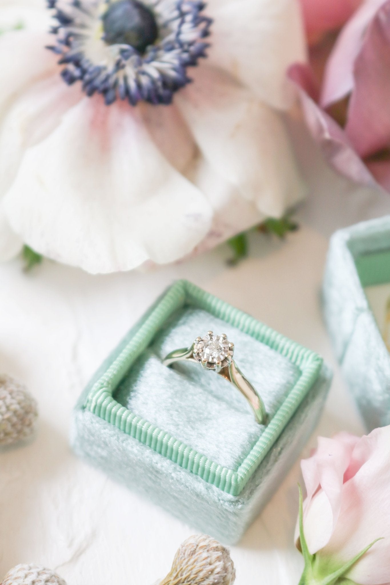 Yellow and White Gold Vintage Engagement Ring in ring box among flowers. 