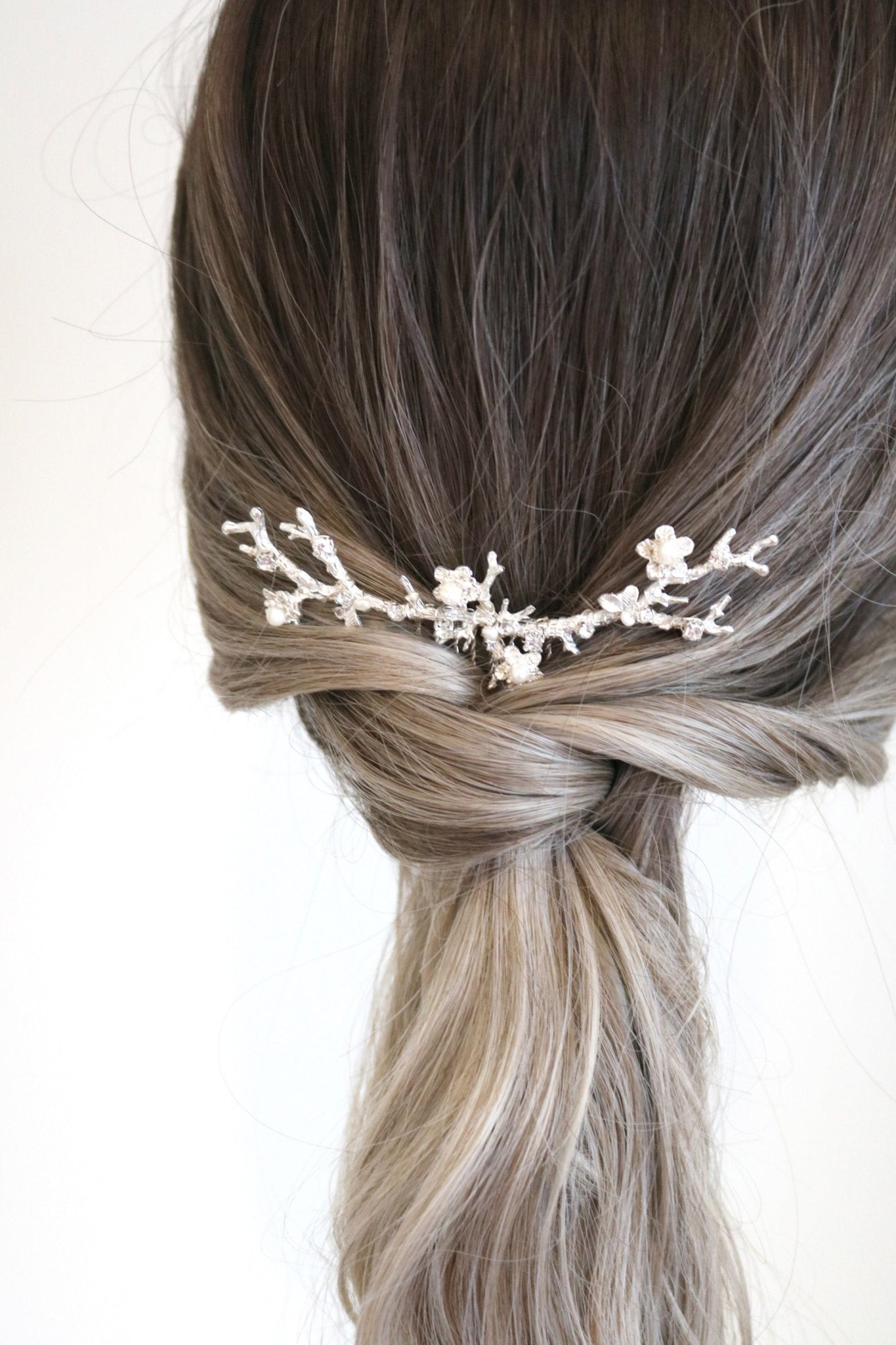 Anthea bridal hair comb for wedding jewelry. Silver floral design set in bridal ponytail. 