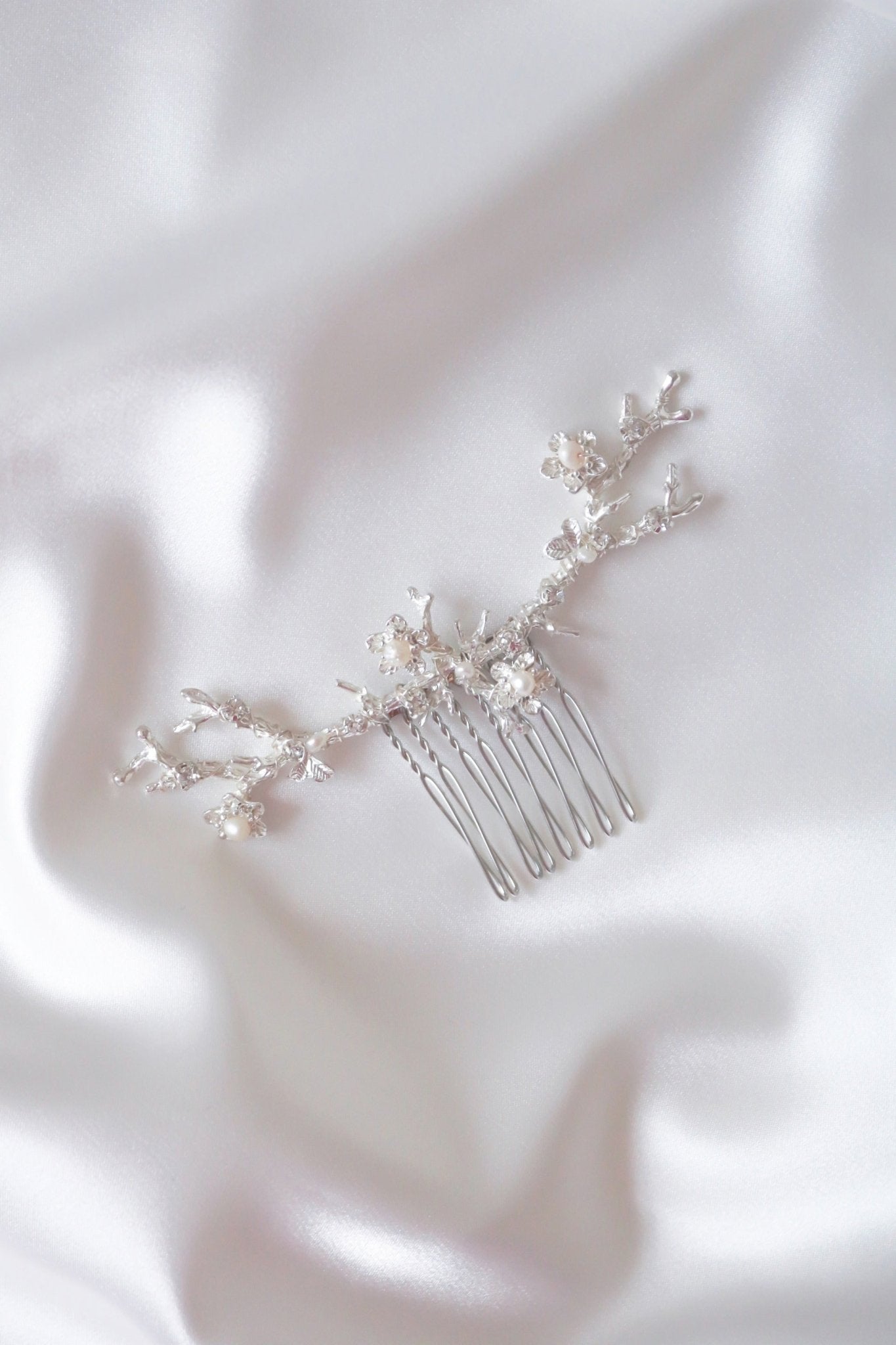 Anthea wide bridal hair accessory silver floral hair comb on white satin.