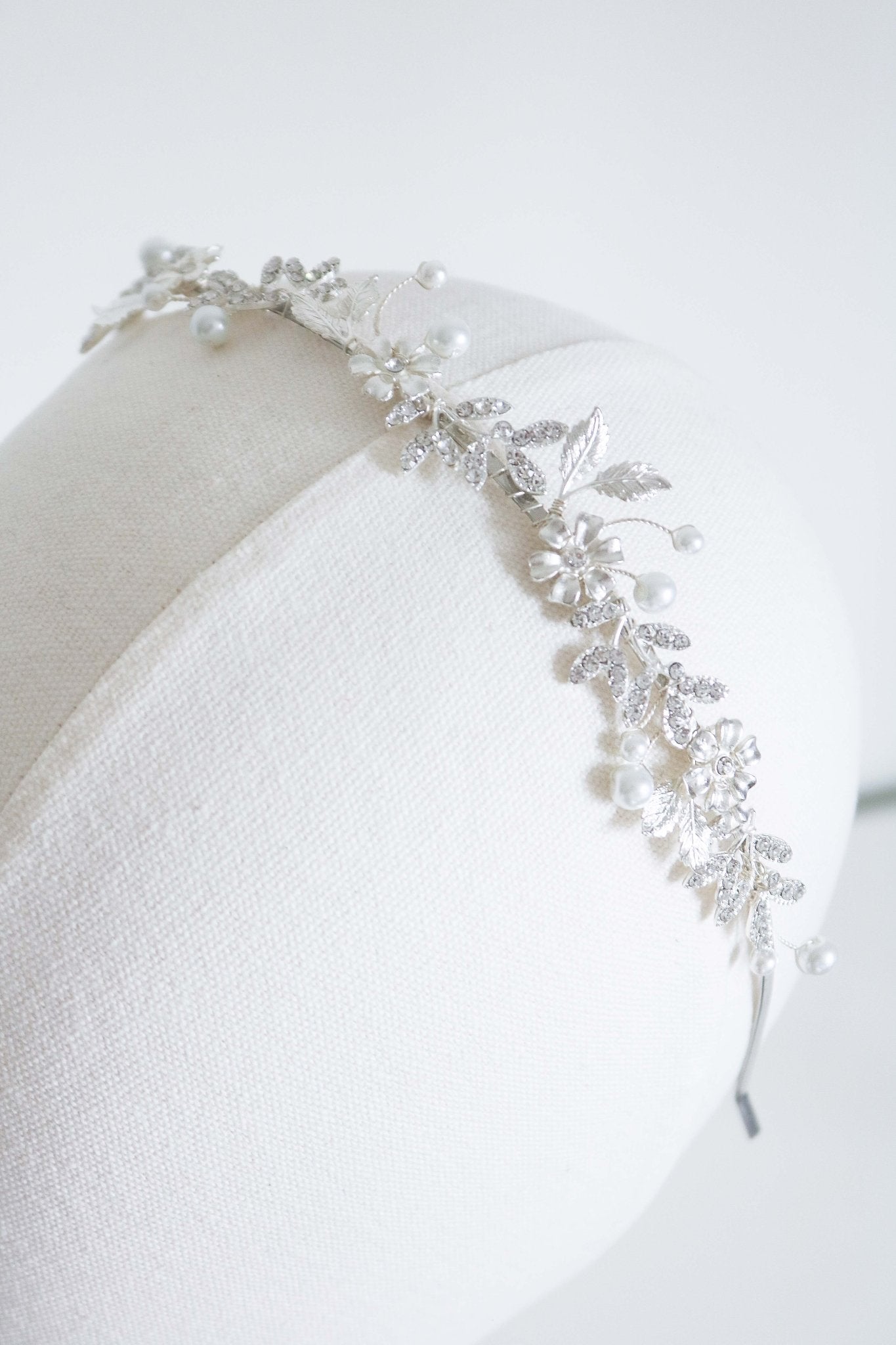 A silver modern bridal headband with wire-wrapped flowers and crystal leaves. 