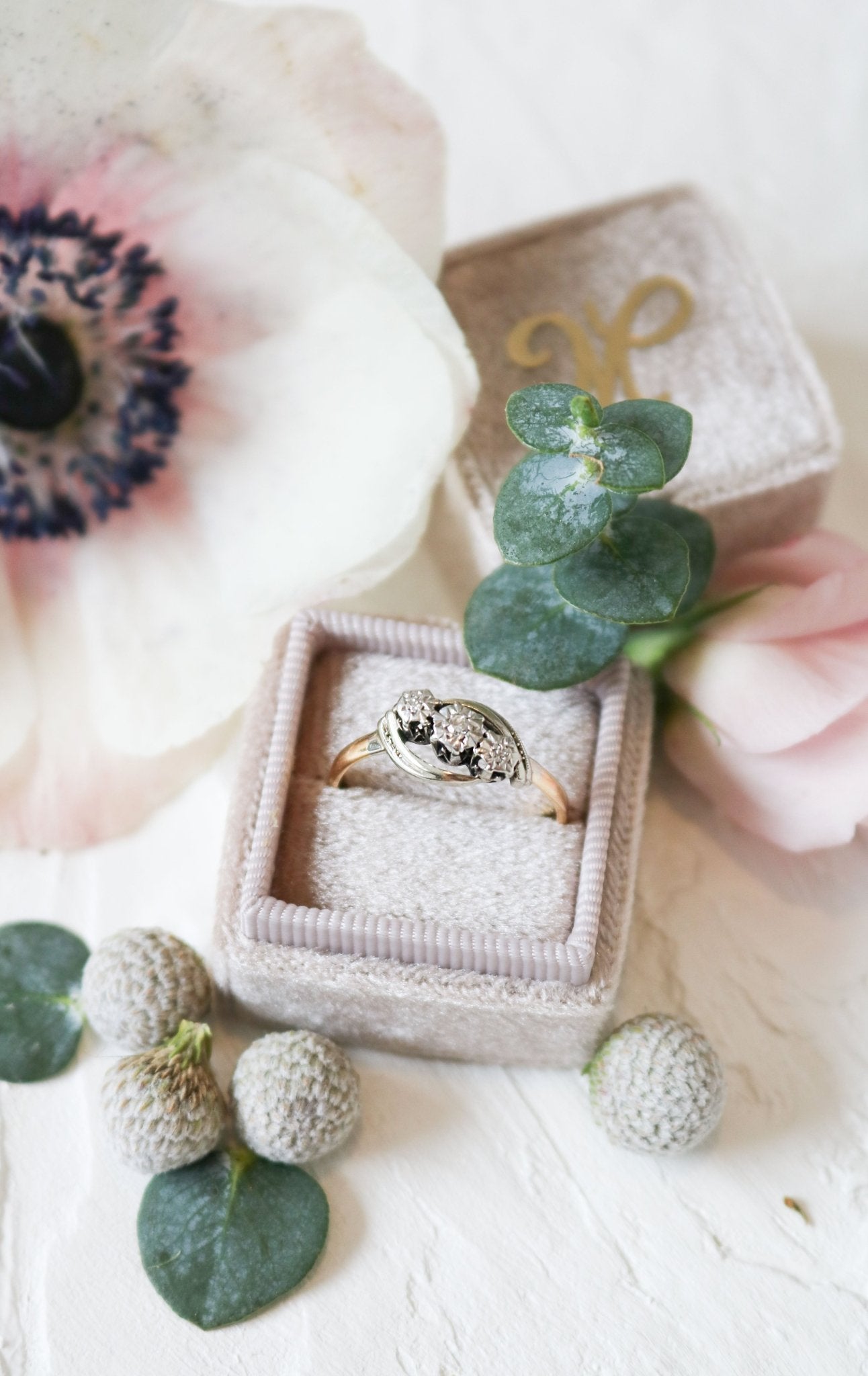 Astra Diamond Trilogy Vintage Engagement Ring in 18ct Gold and Platinum sits in a ring box amongst flora. Antique Engagement Rings Canada. Canadian vintage engagement rings. Vintage engagement rings Canada. Bridal jewelry Canada. Canadian jewelry business. Canadian jewelry brands.