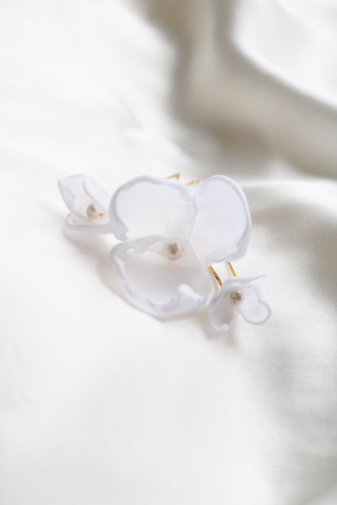 Close up of gold floral mixed 3pc set of bridal hairpins with organic pearls on white backdrop. 