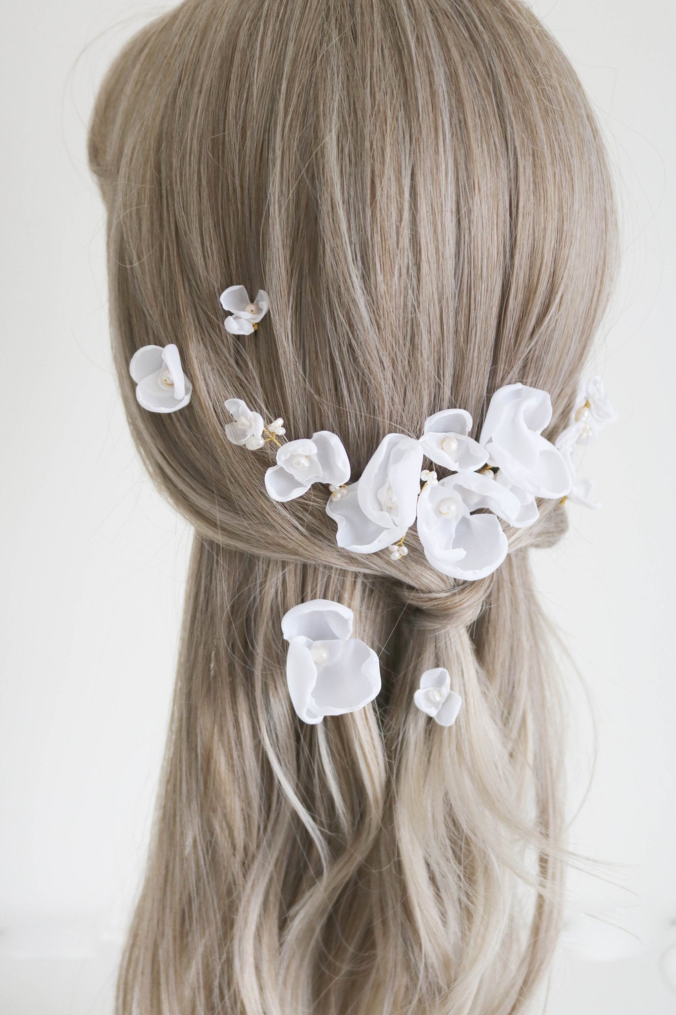 Gold freshwater pearl bridal hair comb set in a loose half ponytail hairdo with mixed singular flower hairpins.