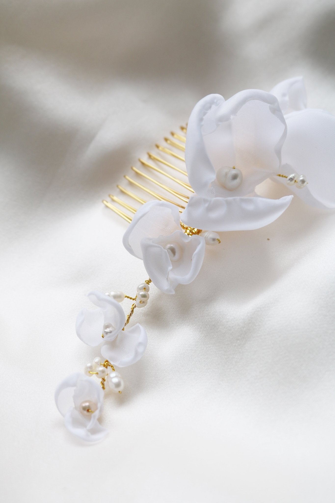 Close up of a gold floral hair comb for wedding hair accessories with freshwater pearls. 