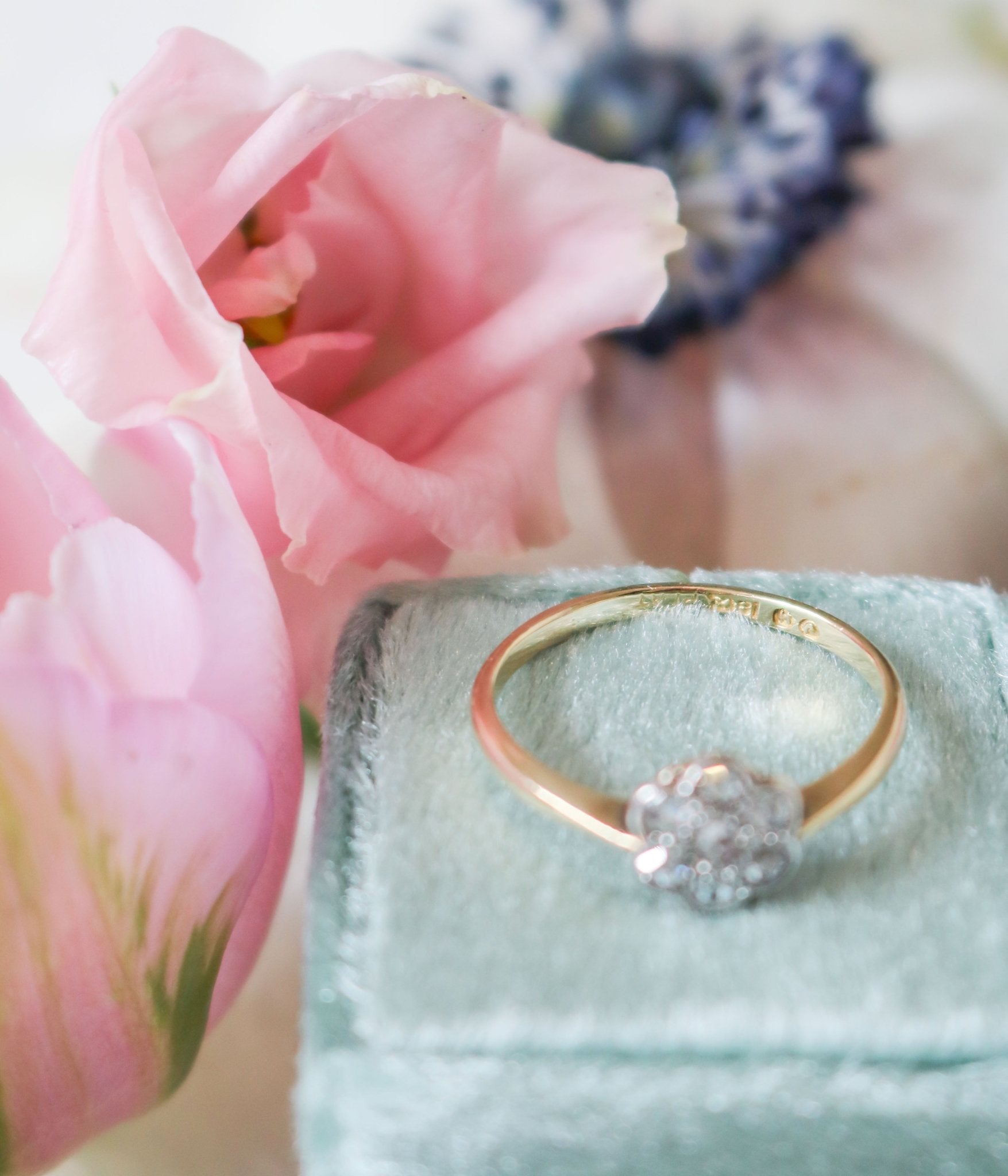 Close up at 18ct yellow gold stamp on vintage engagement ring with diamond flower on top of ring box 