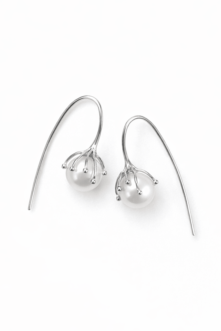 Pair of sterling silver flower bud earrings with freshwater pearls on a white background. Canadian pearl bridal earrings & pearl jewelry handmade by small Canadian jewelry brand