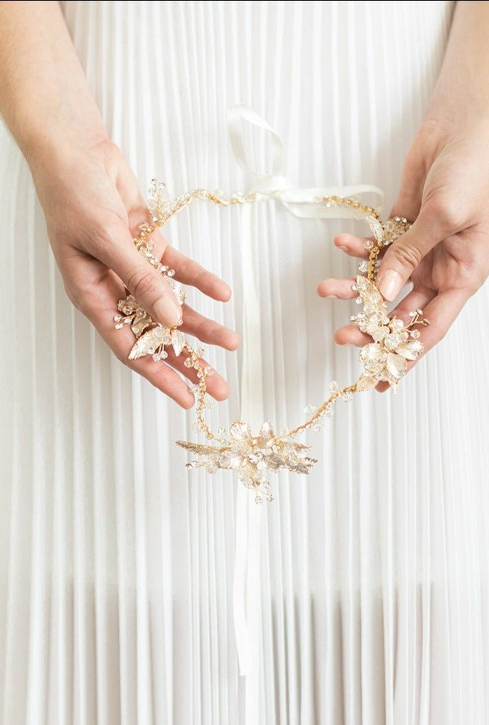 A Bride shows off her Brier Rose Crystal Hairvine by holding it down against her white wedding dress. 