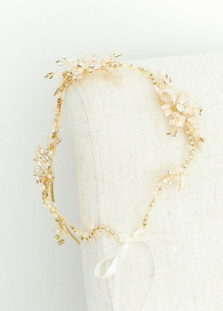 Brier Rose Crystal Hairvine in gold for wedding jewelry hangs off the side of a chair. 