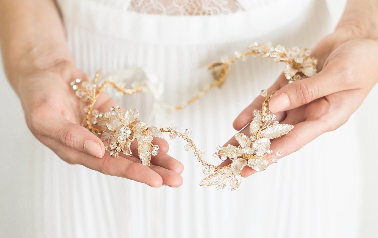 A close up of the Brier Rose Crystal Hairvine being held against a white wedding dress. CBridal Hair Accessories. Bridal Accessories. Canadian Bridal Accessories. Handmade Canadian Accessories. Canadian handmade Accessories. Canadian weddings. Wedding Canada. 