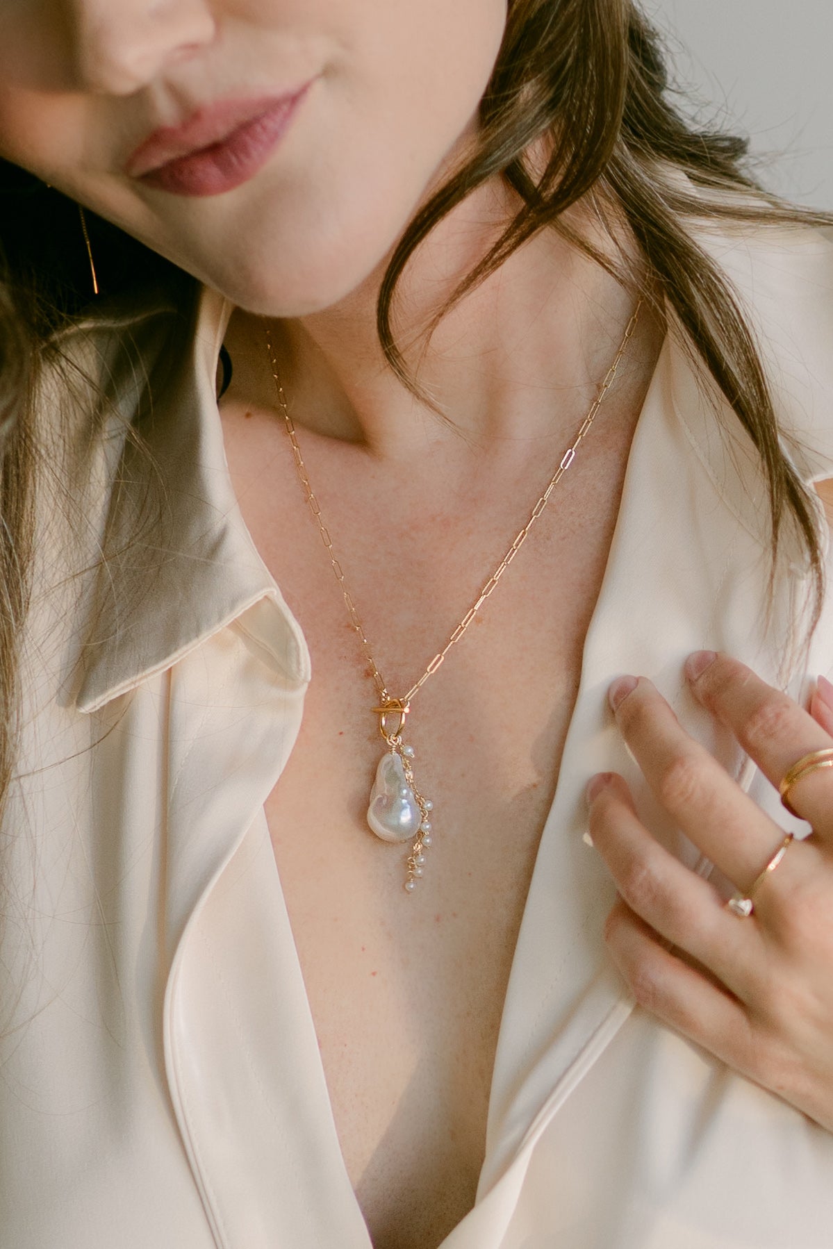 Close up of woman wearing a large freshwater pearl necklace on thin paperclip chain. Organic pearl jewelry. Canadian jewelry designs.