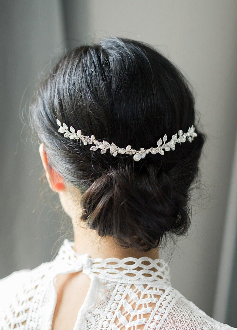 A silver hairvine with freshwater pearls and crystals is delicately placed above a bridal bun. 