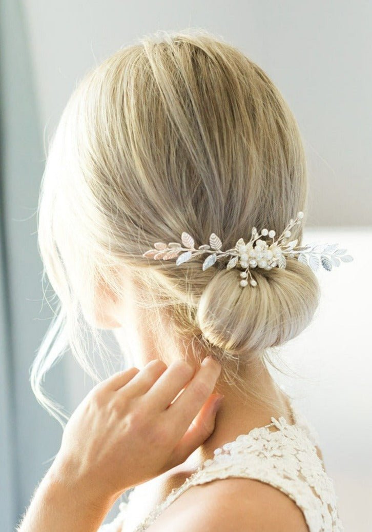 A bride showcases her silver freshwater pearl and crystal leaf wedding hair accessory.