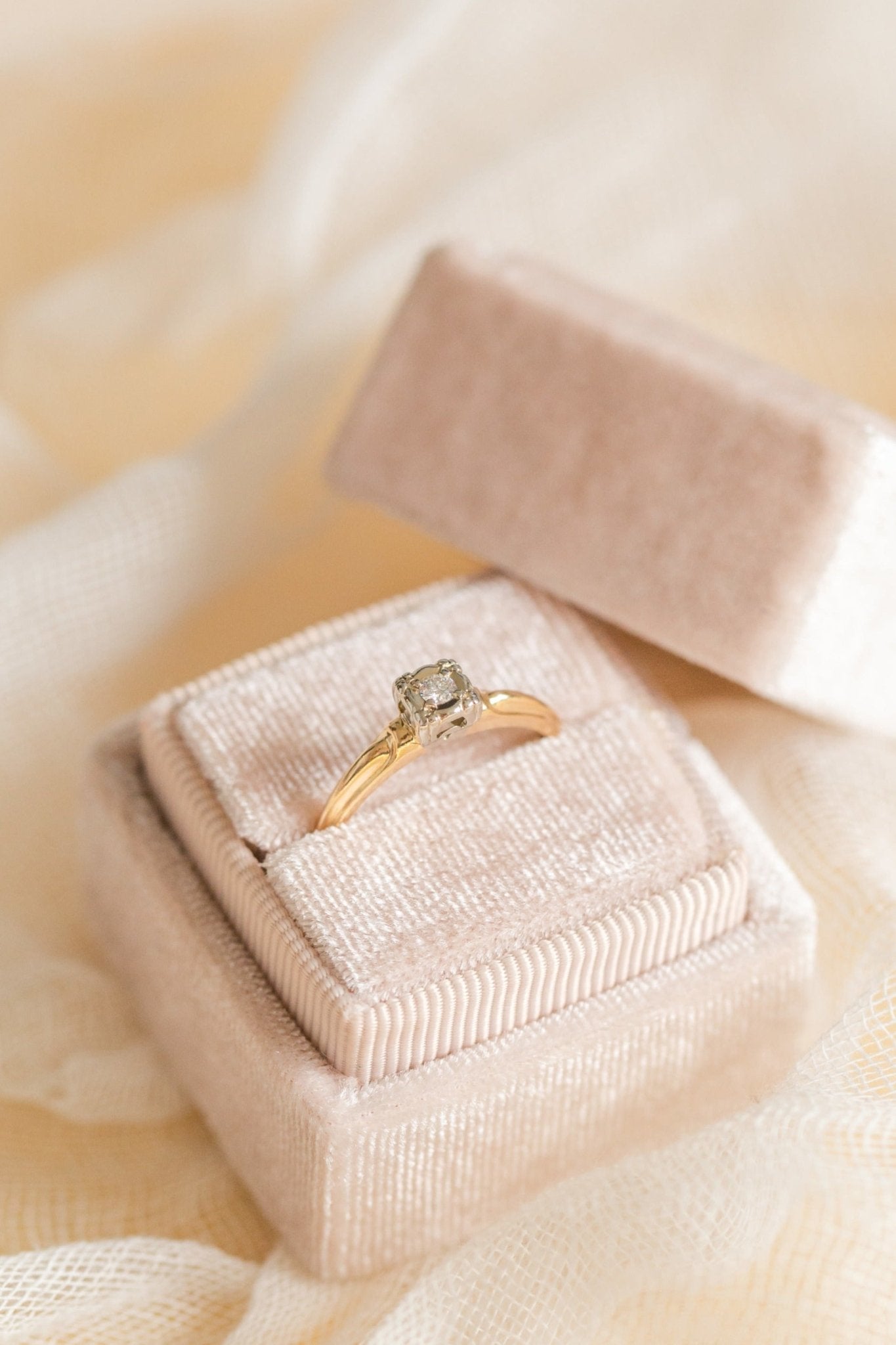 A 14k Gold Diamond Vintage Engagement Ring sits in a ring box with its top leaning against it. 