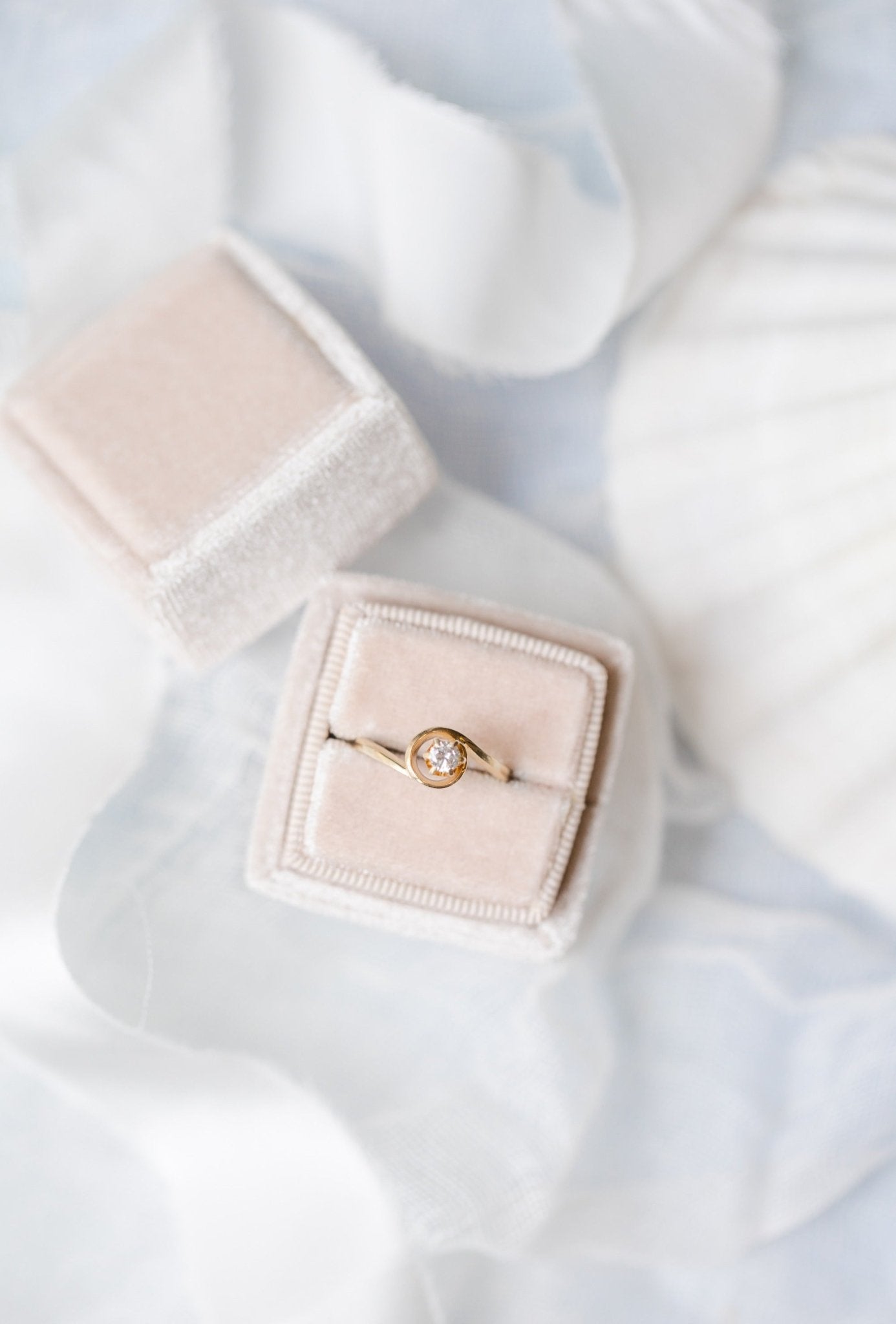 A view from above a 14k Gold Diamond Vintage Engagement Ring sitting in a ring box on a white backdrop. 