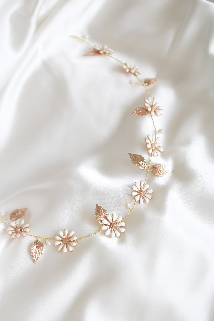 Gold Daisy Chain Hairvine with Fresh Water Pearls against a white satin background. 