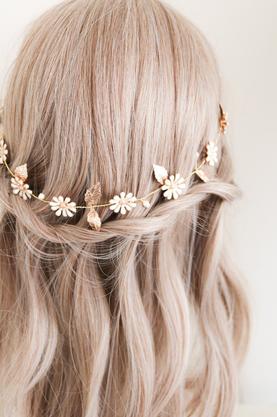 A Gold Daisy Chain Hairvine with Fresh Water Pearls elegantly woven above a bridal hairdo. 