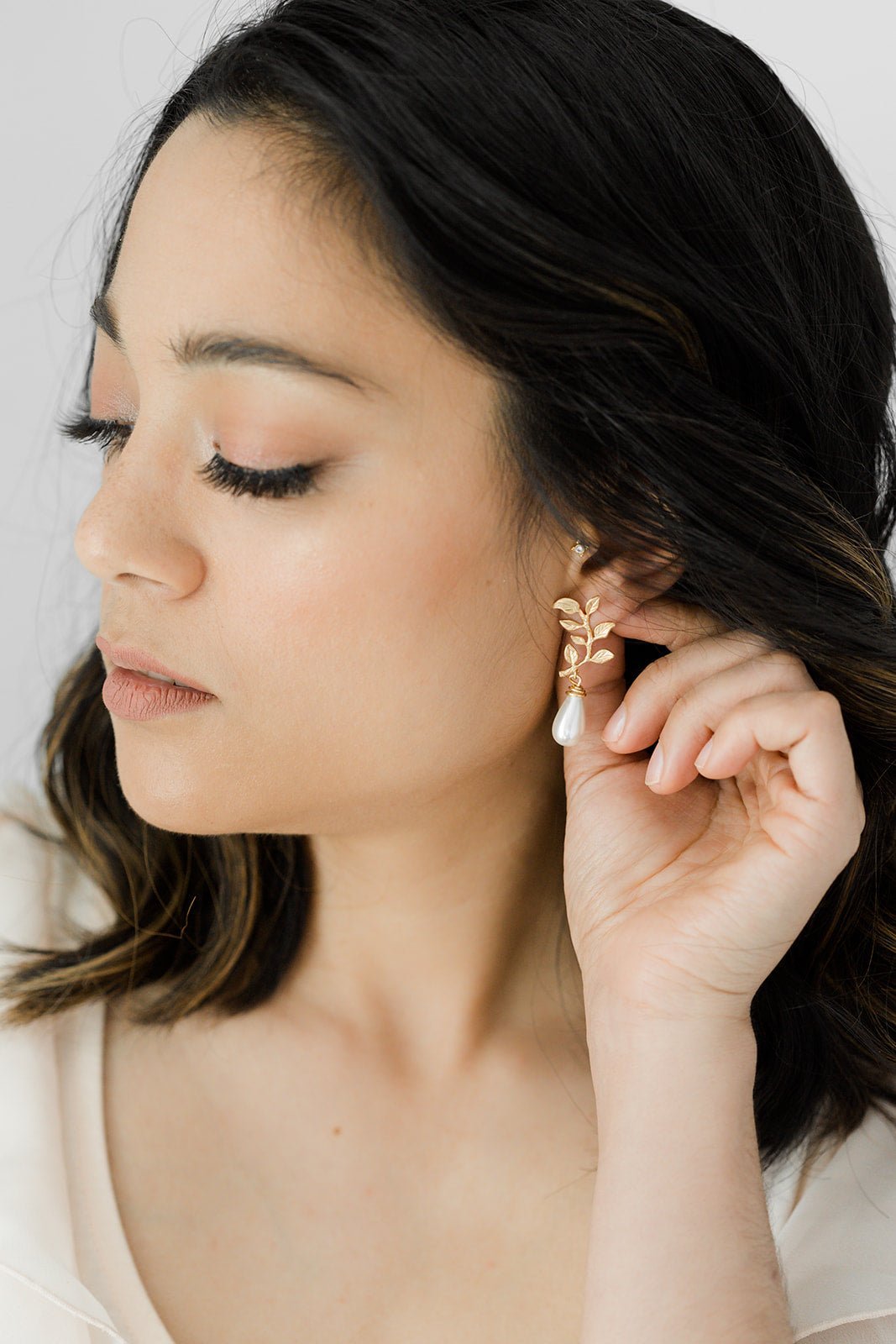 Gold-filled freshwater pearl drop earring being worn. 