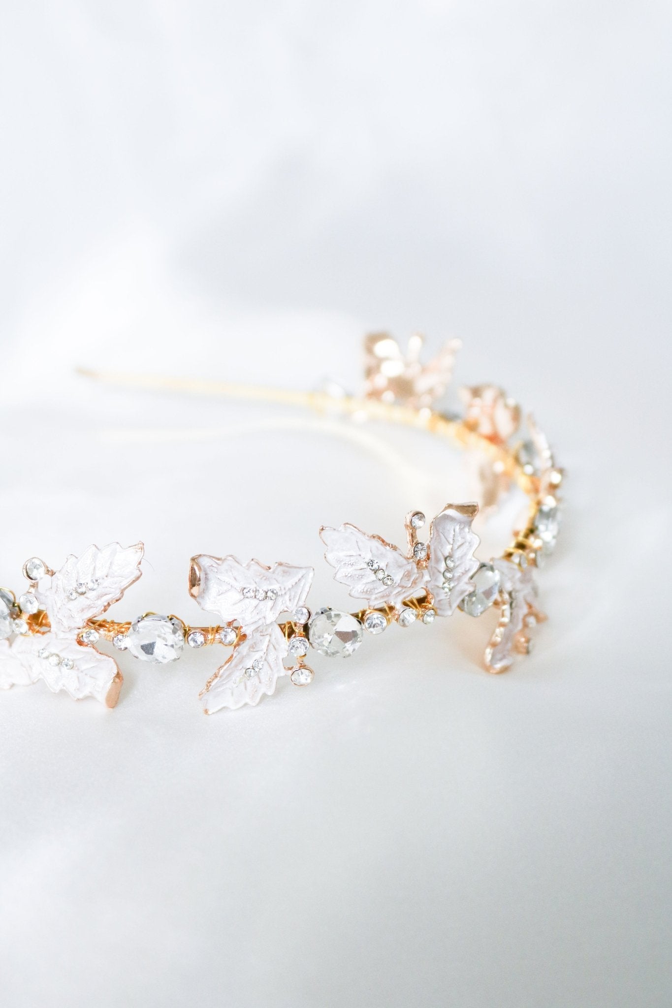 Elegant bridal headband with gold wire-wrapped leaves and staggered crystals.