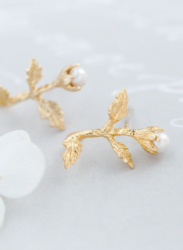 A close up view of a pair of Gold-filled Dancer Freshwater Pearl & Flower Studs.