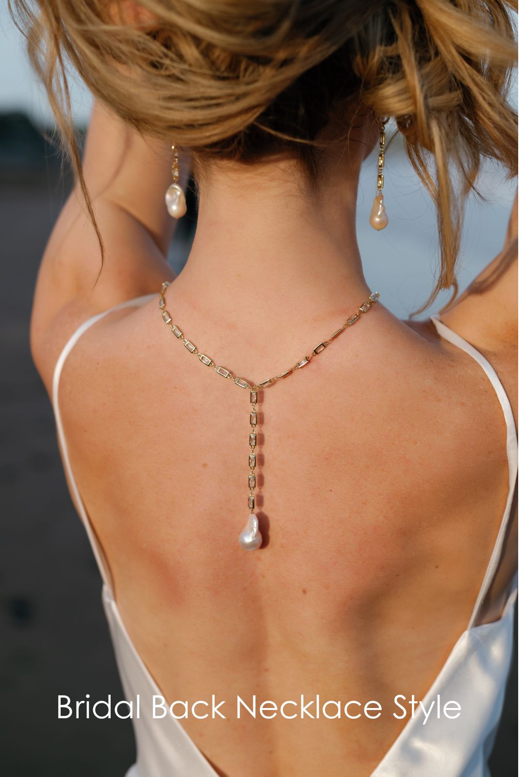 Seaside bride holds her hair up to showcase her Gold filled baroque freshwater pearl earrings and matching lariat style necklace that drapes down her back. Pearl Bridal jewelry Canada.