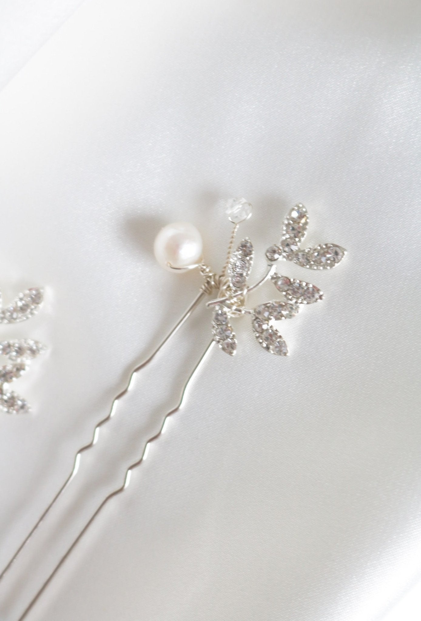 Close up of a silver floral crystal leaf bridal hairpin with a fresh water pearl on a white background. Pearl bridal hair accessories & Canadian bridal accessories handmade by Canadian wedding designer