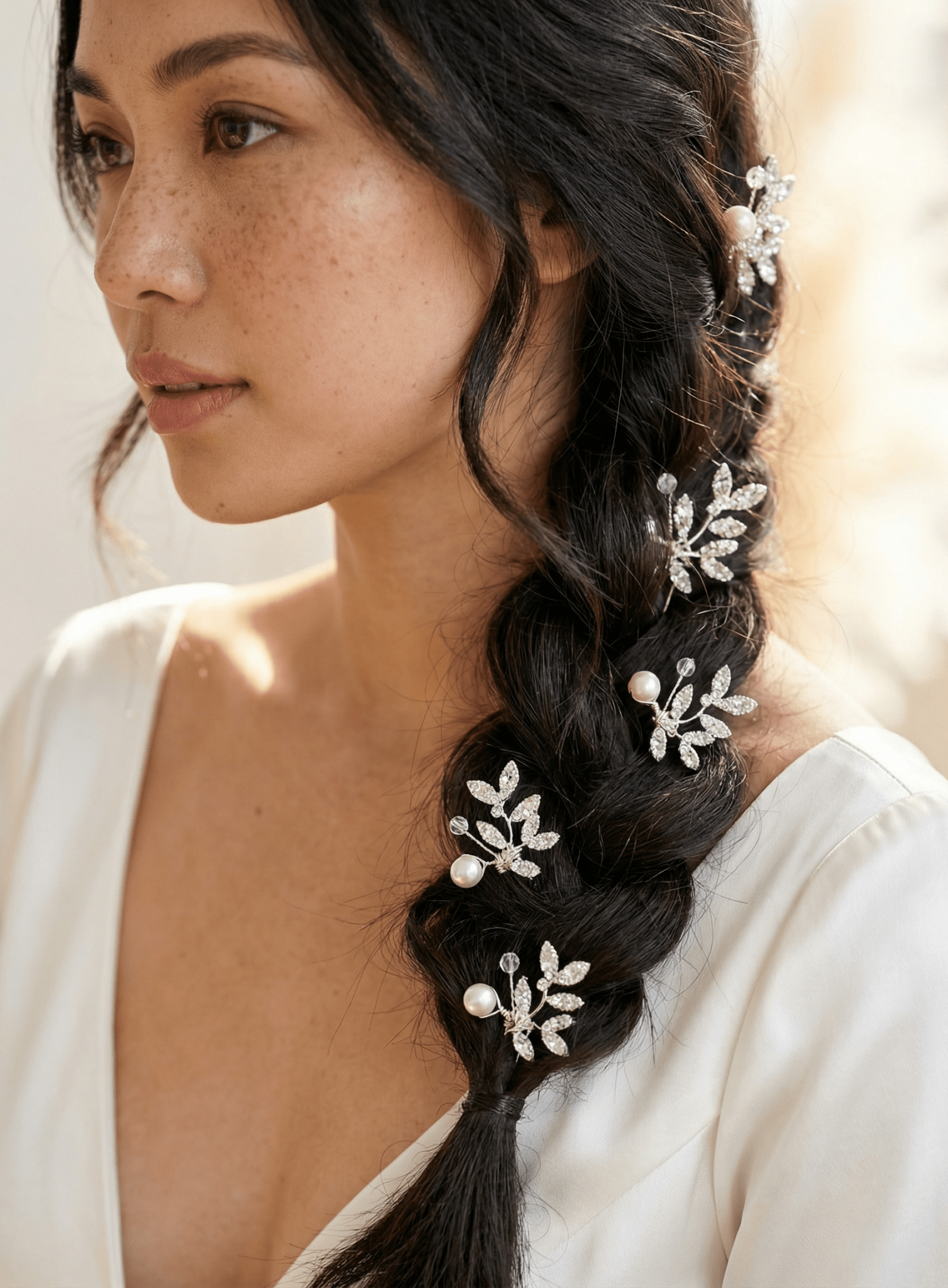 Woman with braided hair adorned with decorative hairpins against a neutral background, canadian bridal accessories