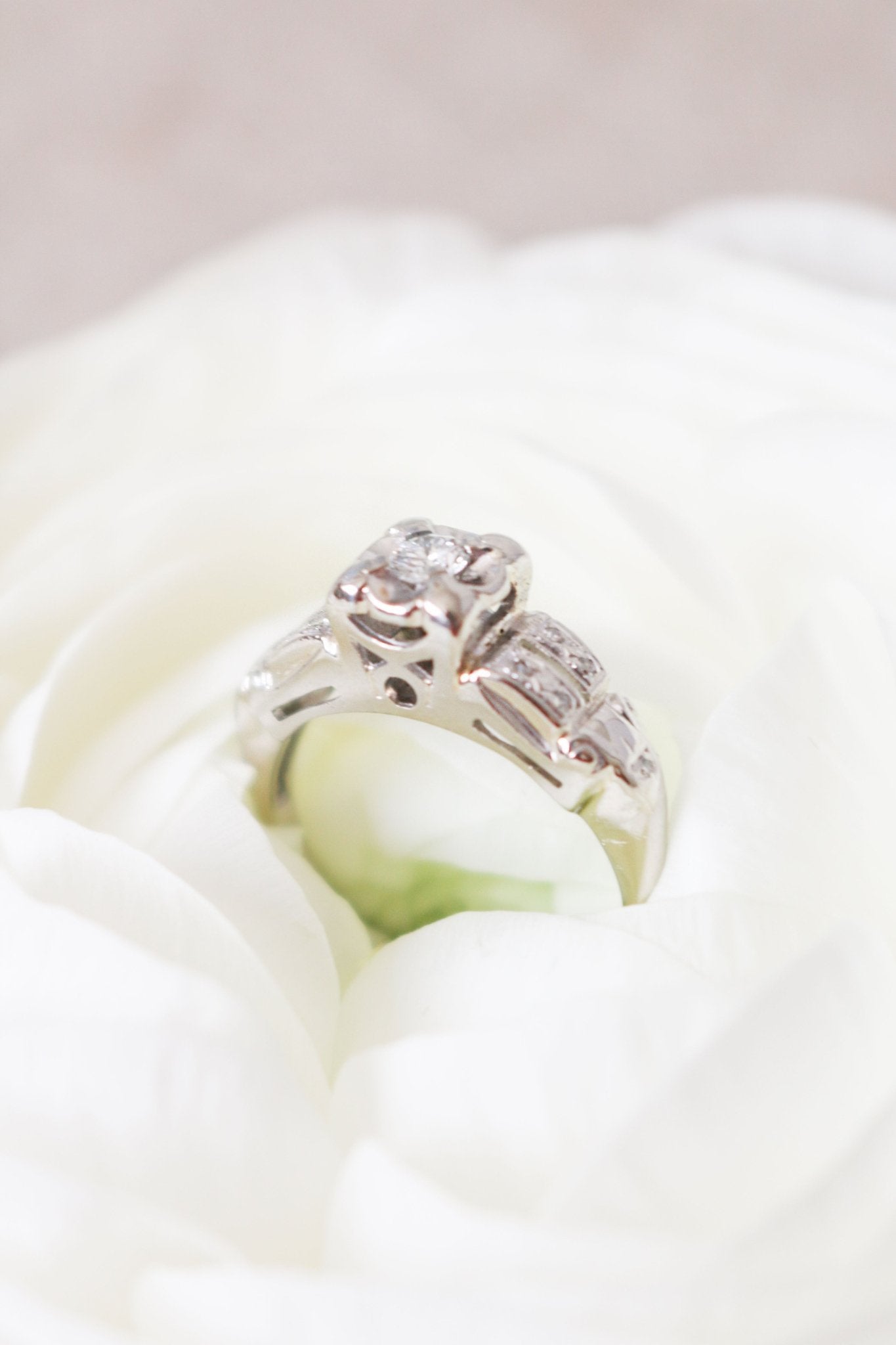 14k White Gold and Diamond Vintage Engagement Ring sits inside a white rose. 