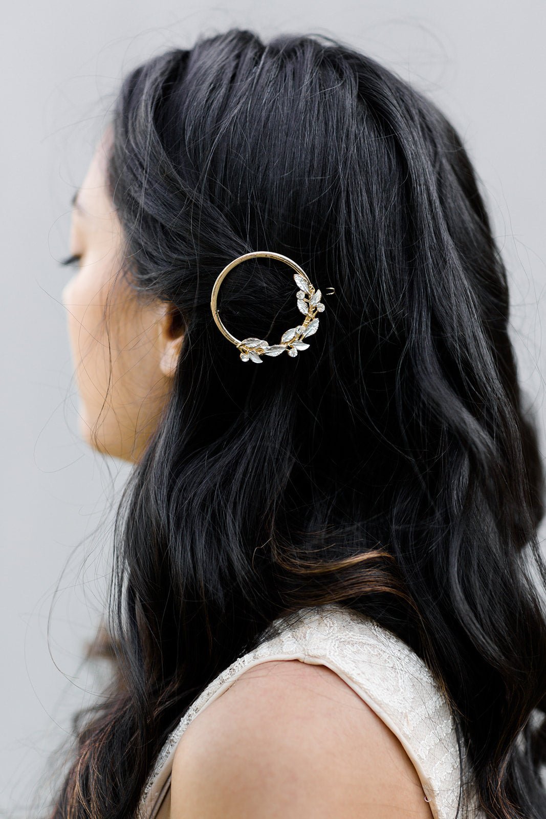 Gold Crystal and Leaf Barrette pinning up long dark curled hair. 