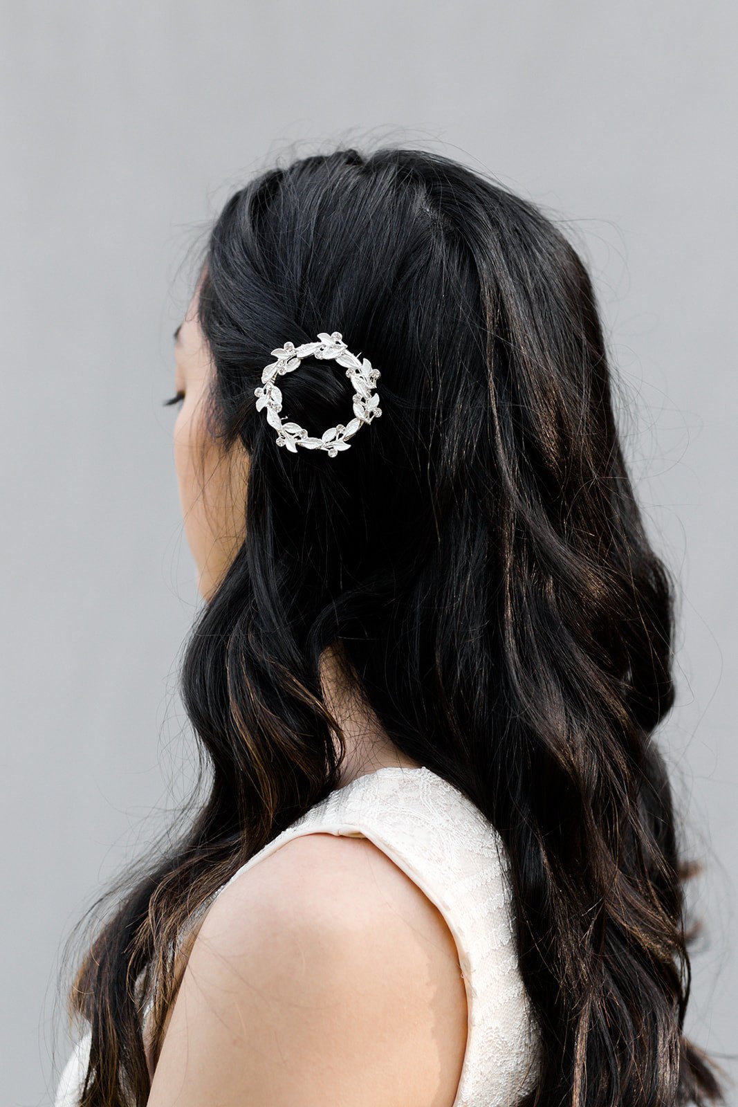 Full Silver wreath barrette with crystals pinning long dark hair.