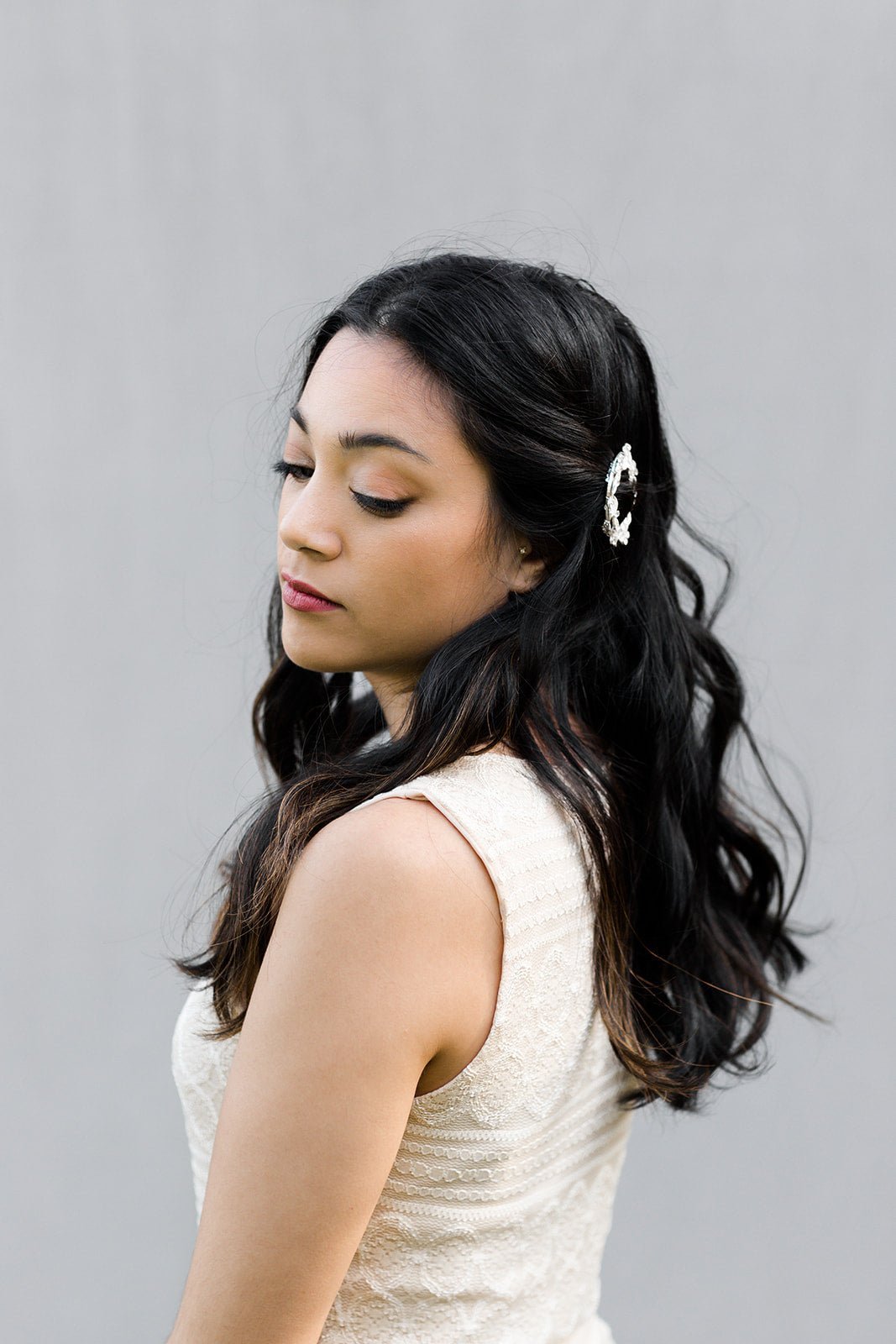 Fancy silver full leaf barrette with crystals delicately pinning back a beautiful woman's hair.