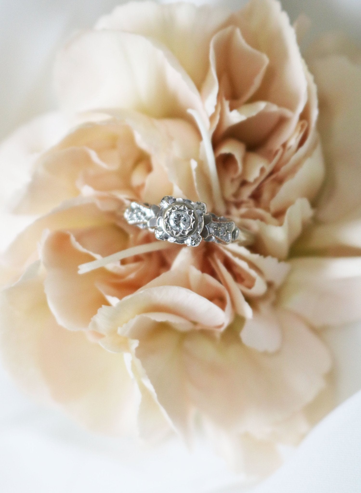 A 14k White Gold Diamond Vintage Engagement Ring nestled in petals of a flower. Canadian vintage engagement rings. Bridal jewelry Canada. Wedding Canada. Small Canadian jewelry brands. Canadian bridal jewelry. Woman-owned Canadian jewelry brand. Canadian jewelry business.